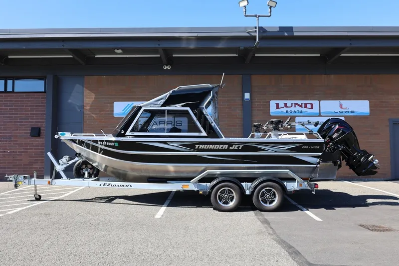 Slide: The Image of 2025 Thunder Jet 200 Luxor boat on trailer, parked outside a dealership. - 2