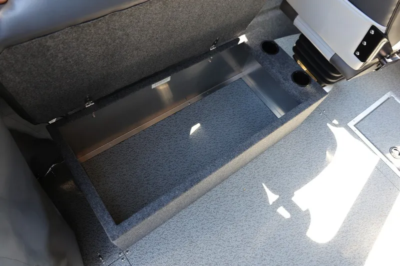 Slide: The Image of 2025 Thunder Jet 200 Luxor interior storage compartment with cup holders and gray upholstery. - 36