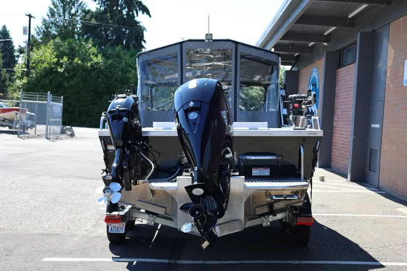 Slide: The Image of 2025 Thunder Jet 200 Luxor boat with dual outboard motors in a parking lot. - 5