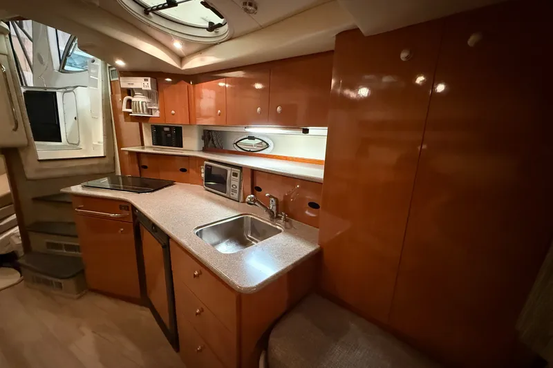 Slide: The Image of 2005 Maxum 3300 SE yacht interior kitchen with modern appliances and wooden cabinetry. - 39