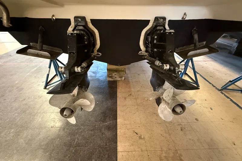 Slide: The Image of 2005 Maxum 3300 SE boat propellers and stern drive on display in a workshop. - 6