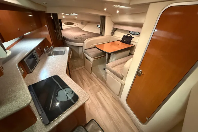 Slide: The Image of 2005 Maxum 3300 SE yacht interior with kitchenette, dining area, and cozy sleeping quarters. - 31