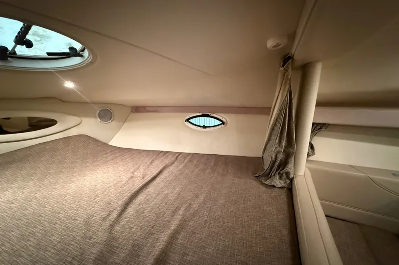 Slide: The Image of 2005 Maxum 3300 SE cabin interior with bed, porthole, and curtain. - 42