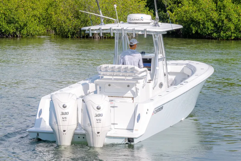 Slide: The Image of 2024 Contender 32 ST boat with dual 300 V6 engines navigating calm waters. - 4