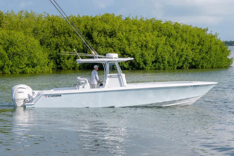 Slide: The Image of 2024 Contender 32 ST boat cruising on water near lush green mangroves. - 3
