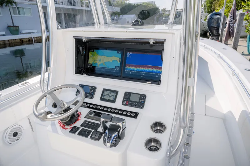 Slide: The Image of 2024 Contender 32 ST boat dashboard with navigation screens and controls. - 14
