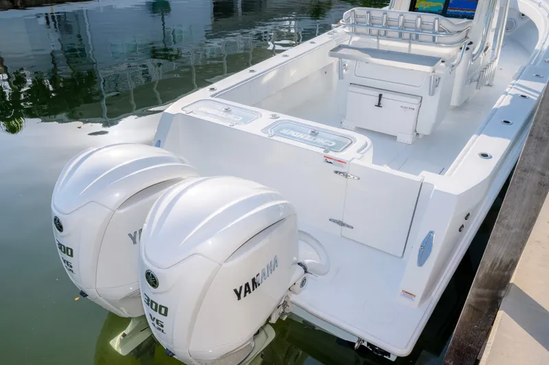 Slide: The Image of 2024 Contender 32 ST boat with dual Yamaha 300 engines docked by the water. - 13