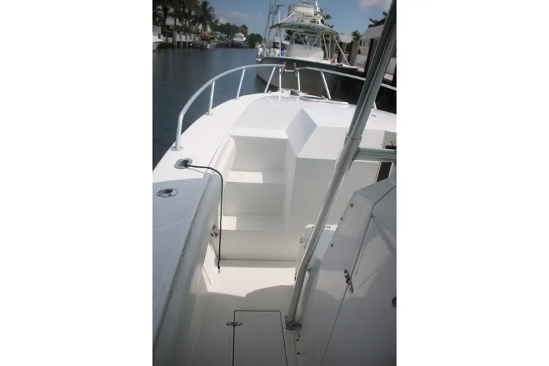 Slide: The Image of 1996 Jupiter 31 Center Console boat docked, showcasing sleek white deck and railing. - 10