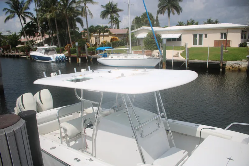 Slide: The Image of 1996 Jupiter 31 Center Console boat docked near waterfront homes and palm trees. - 6