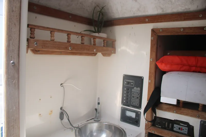 Slide: The Image of Interior of a 1996 Jupiter 31 Center Console boat with sink and storage. - 14