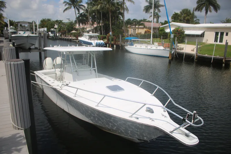 Slide: The Image of 1996 Jupiter 31 Center Console boat docked in a scenic marina setting. - 3