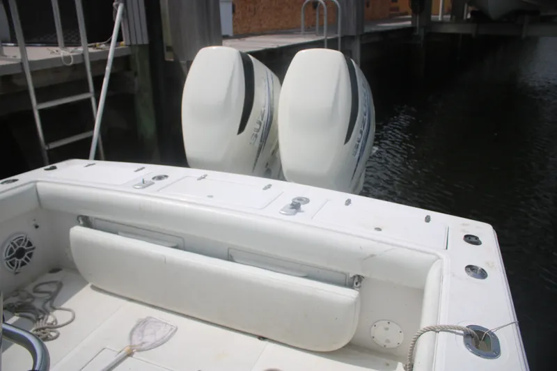 Slide: The Image of 1996 Jupiter 31 Center Console boat with twin outboard engines docked by the water. - 22