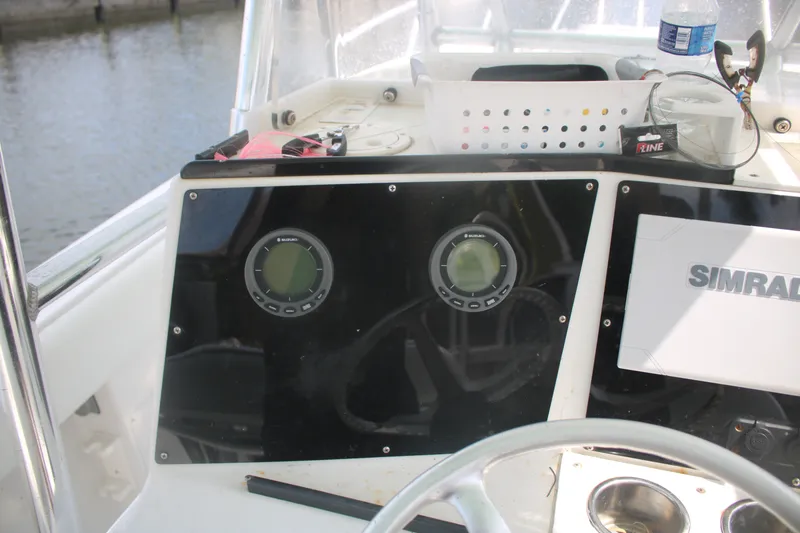 Slide: The Image of 1996 Jupiter 31 Center Console boat dashboard with Simrad electronics and Suzuki gauges. - 23