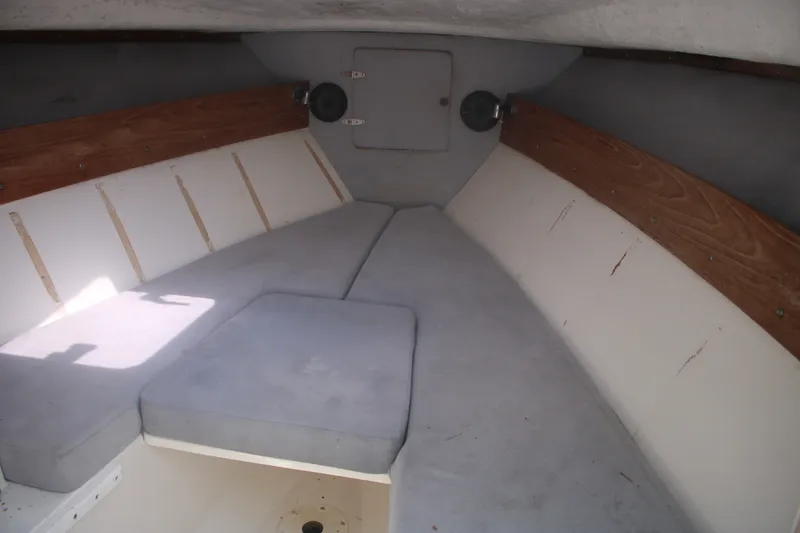 Slide: The Image of Interior cabin of a 1996 Jupiter 31 Center Console boat, featuring cushioned seating. - 11