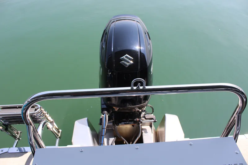 Slide: The Image of An outboard motor on a boat, resting on calm water. Stainless steel railings are visible. - 21