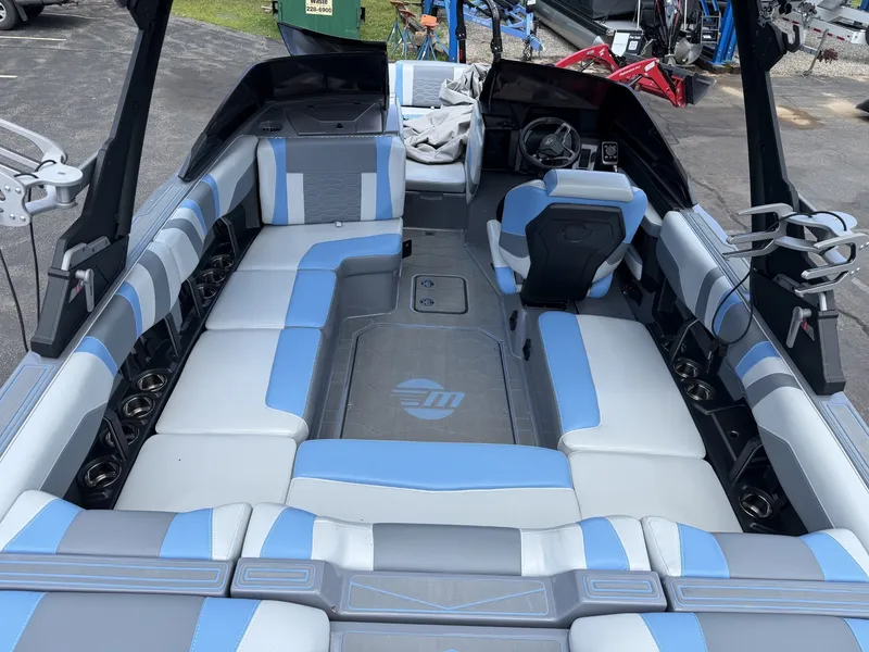 Slide: The Image of The image shows the interior of a 2025 Malibu Wakesetter 22 MXZ with blue and gray seating. - 23