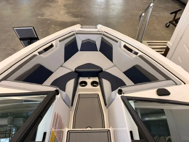 Slide: The Image of The image shows the bow of a 2026 MasterCraft ProStar with cushioned seating and cup holders. - 13