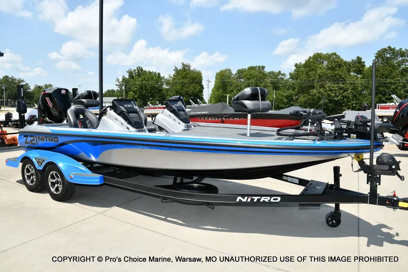 Slide: The Image of A 2021 Nitro Z21 Pro boat on a trailer, surrounded by trees and a clear sky. - 2