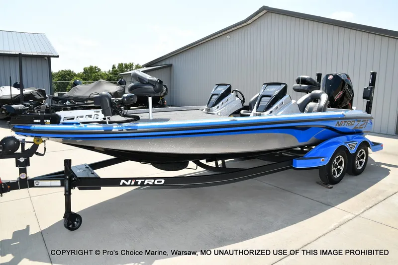 Slide: The Image of 2021 Nitro Z21 Pro, a sleek blue and silver fishing boat, sits on a trailer. - 28