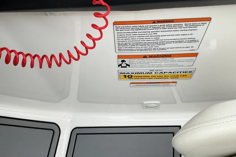 Slide: The Image of Warning labels and capacity information on a boat with a red safety cord. - 16
