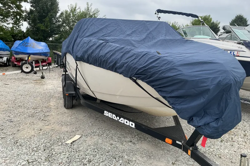 Slide: The Image of A 2010 Sea-Doo Sport Boat, model 210 Challenger SE, is on a trailer with a blue cover. - 5