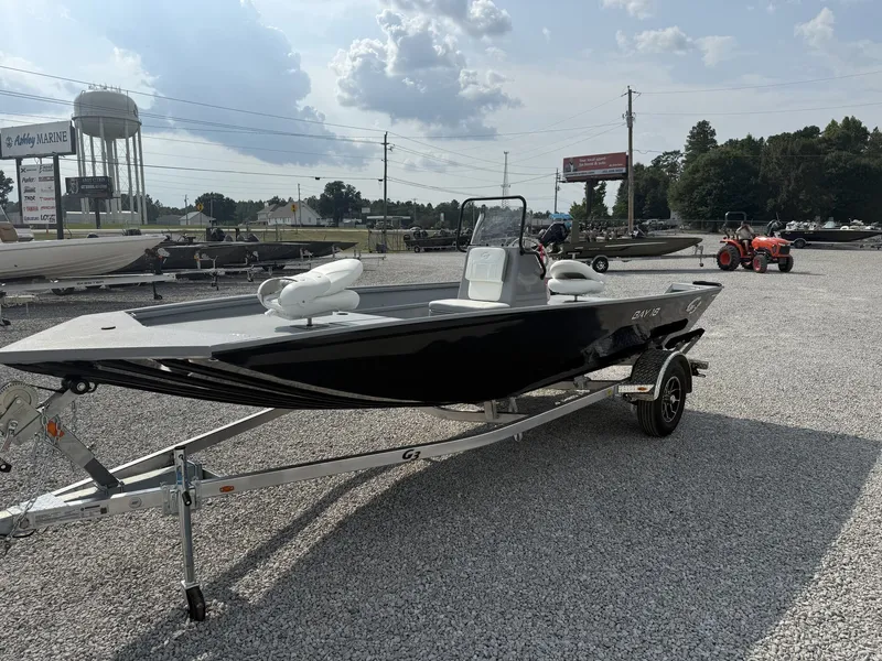 Slide: The Image of A black G3 Bay 18 BAY-F90 SHO boat from 2027 sits on a trailer in a gravel lot. - 3