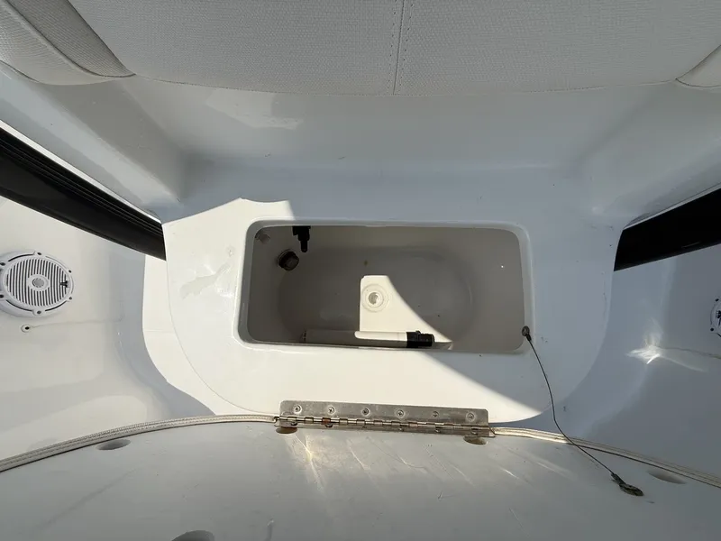 Slide: The Image of An open storage compartment on a boat with white upholstery and speakers. - 7