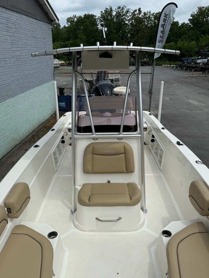 Slide: The Image of The image shows a 2019 NauticStar 231 HYBRD CC boat with beige seating and a T-top. - 13