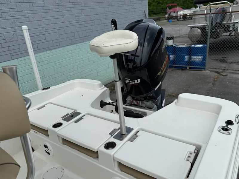 Slide: The Image of A 2019 NauticStar 231 HYBRD CC with a 250 HP outboard motor. It features a white deck and elevated seat. - 8