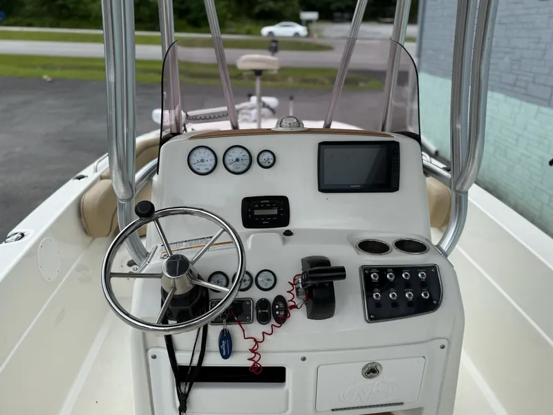 Slide: The Image of The image shows the helm of a 2019 NauticStar 231 HYBRD CC with steering wheel and instruments. - 9