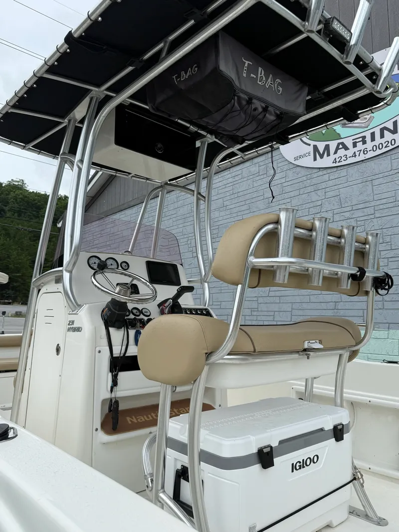 Slide: The Image of The image shows the cockpit of a 2019 NauticStar 231 HYBRD CC with beige seating and helm console. - 6