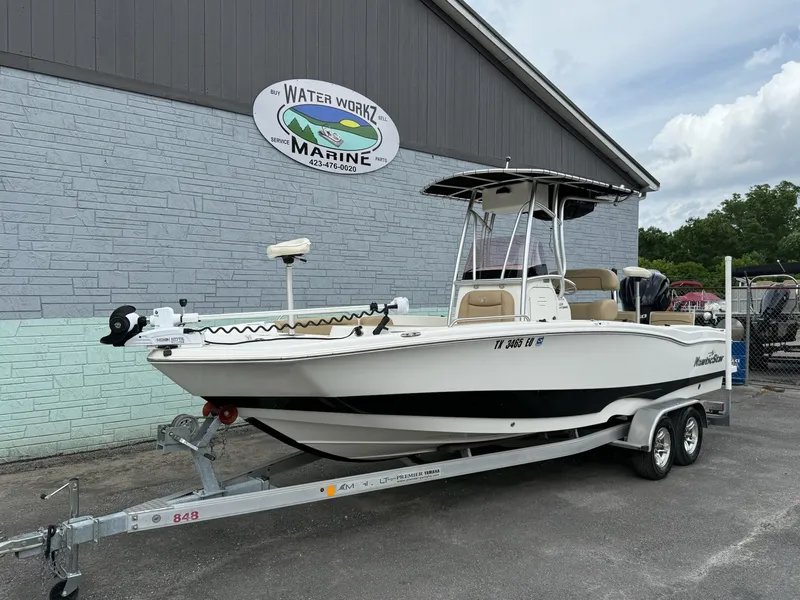 Slide: The Image of A white boat on a trailer in front of a building with a "Water Workz Marine" sign. - 2