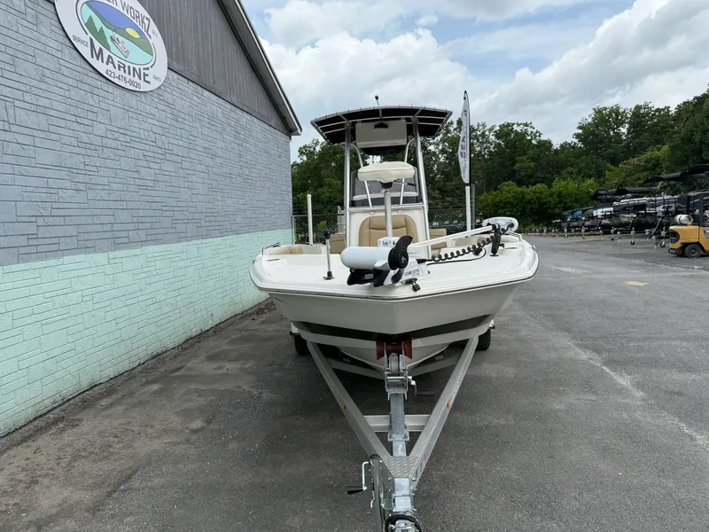 Slide: The Image of A 2019 NauticStar 231 HYBRD CC on a trailer, parked beside a building. - 3