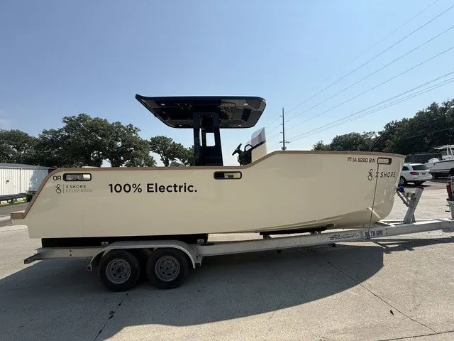 Slide: The Image of A modern electric boat on a trailer. It features a minimalist design and is cream-colored. - 22