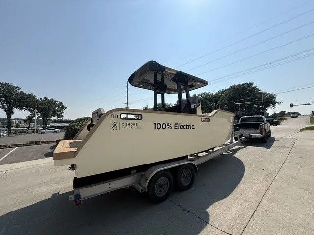 Slide: The Image of A 2023 X Shore Eelex 8000 boat on a trailer, featuring "100% Electric" text. - 12