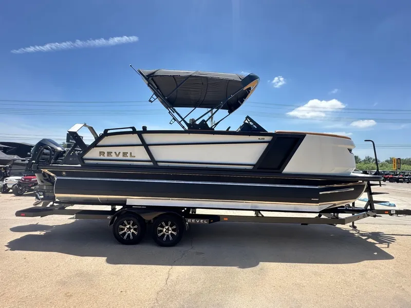 Slide: The Image of The image shows a 2027 Revel RL23 boat on a trailer. It features a modern design and a sunshade. - 7