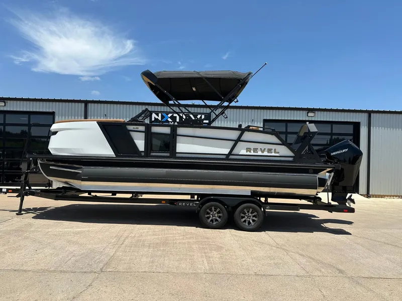 The Image of The image shows a 2027 Revel RL23 boat on a trailer in front of a building. - 1