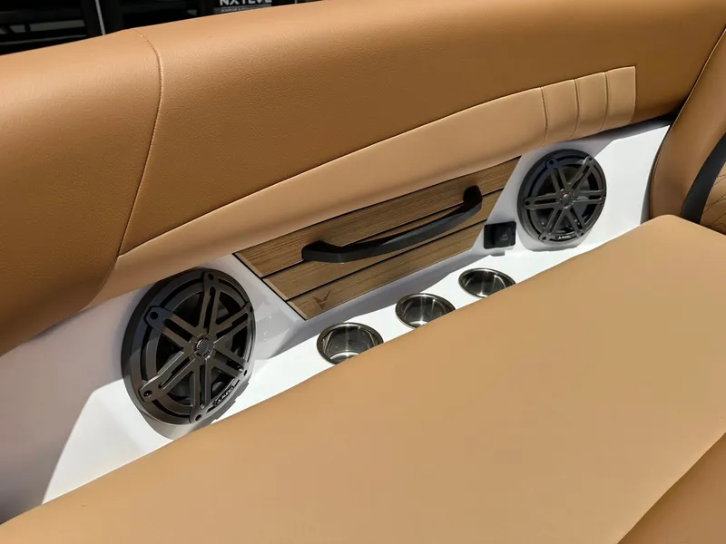 Slide: The Image of The interior of the 2027 Revel RL23 features brown upholstery, speakers, and cup holders. - 14
