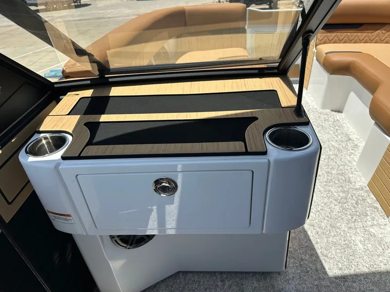 Slide: The Image of The image shows a boat interior with sleek, modern design. There's a cushioned bench and a table with cup holders. - 25