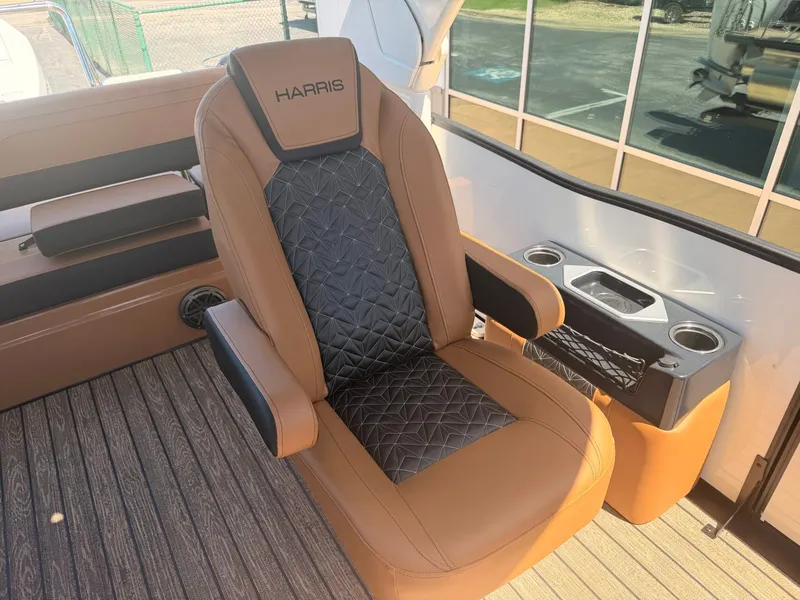 Slide: The Image of Luxurious captain's chair on a Harris Grand Mariner 250, featuring brown and black upholstery and cup holders. - 18