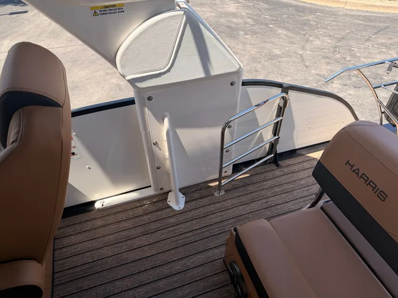 Slide: The Image of The image shows the deck of a 2027 Harris Grand Mariner 250 with brown seats and metal railing. - 23