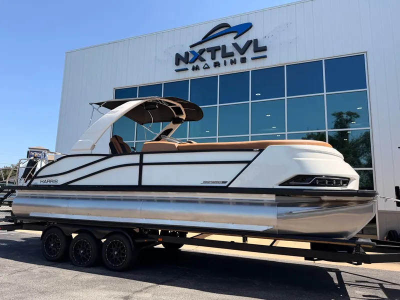 The Image of A 2027 Harris Grand Mariner 250 on a trailer in front of a modern building. - 1