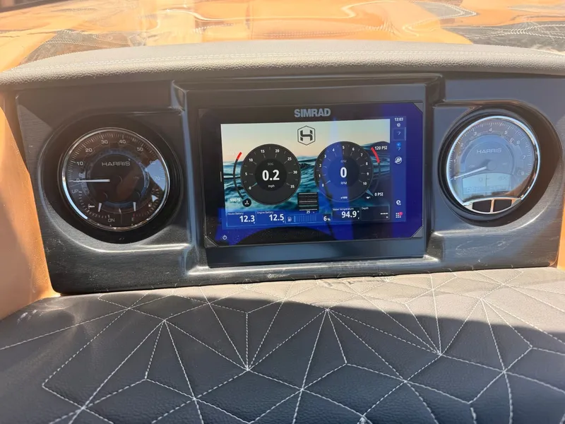 Slide: The Image of The image shows the dashboard of a Harris Grand Mariner 250 with a Simrad display and two analog gauges. - 16