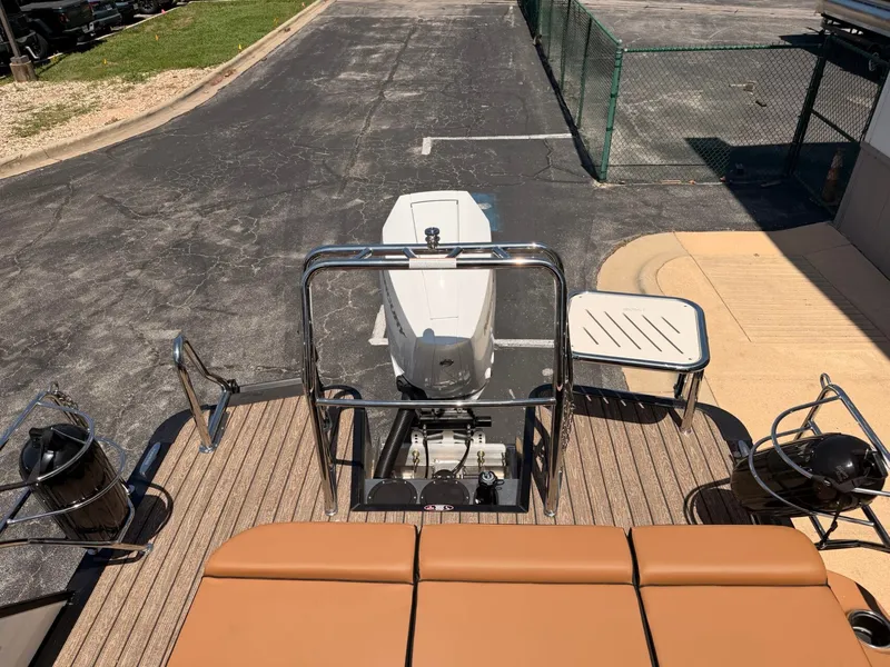Slide: The Image of The image shows the stern of a 2027 Harris Grand Mariner 250 with an outboard motor and cushioned seating. - 22