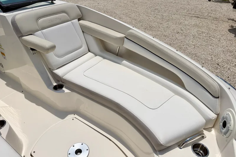 Slide: The Image of 2013 Sea Ray 260 Sundeck boat interior with white cushioned seating. - 10