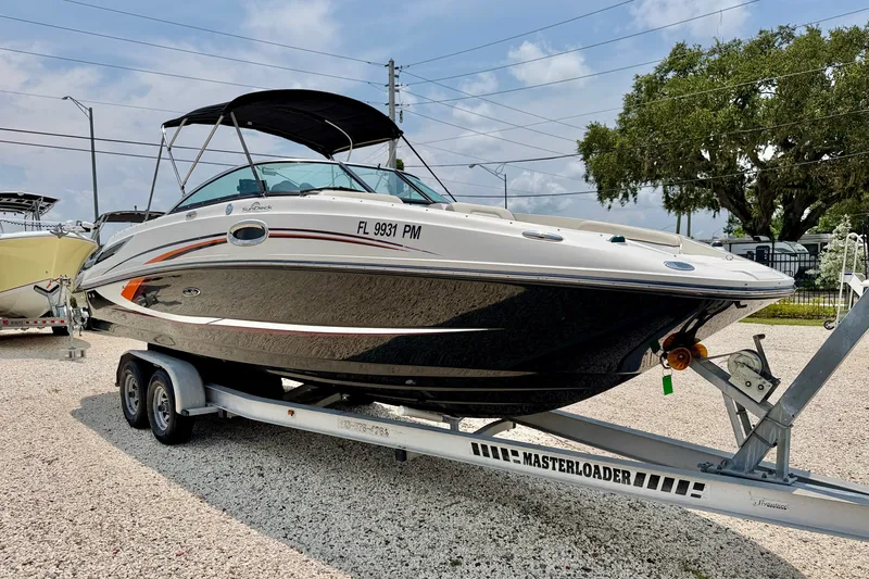 Slide: The Image of 2013 Sea Ray 260 Sundeck boat on trailer, parked outdoors under a clear sky. - 3