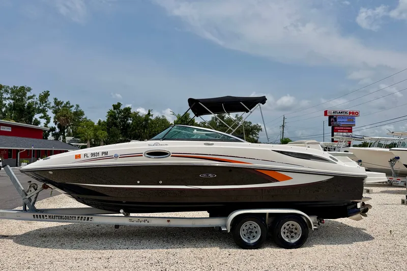 The Image of 2013 Sea Ray 260 Sundeck boat on trailer, parked outdoors under a clear sky. - 0