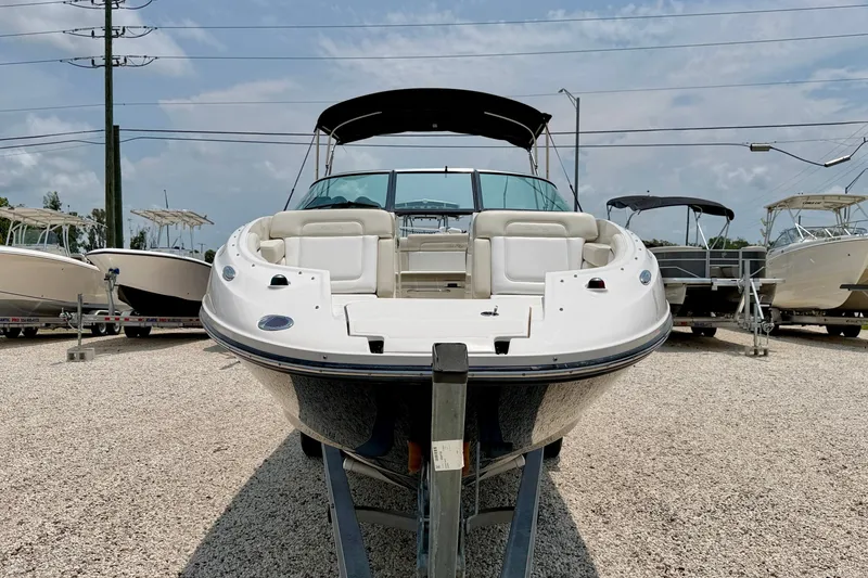 Slide: The Image of 2013 Sea Ray 260 Sundeck boat displayed on a gravel lot, surrounded by other boats. - 2