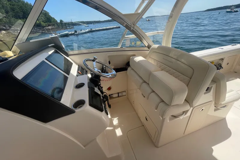 Slide: The Image of Interior of 2021 Grady-White Freedom 325 boat with helm and seating, overlooking water. - 21