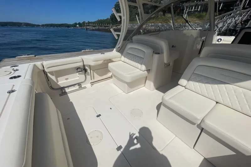 Slide: The Image of 2021 Grady-White Freedom 325 boat interior with white seating, docked by the water. - 30